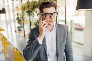 Oturma ve cep telefonu kullanma office işadamı gülümseyen