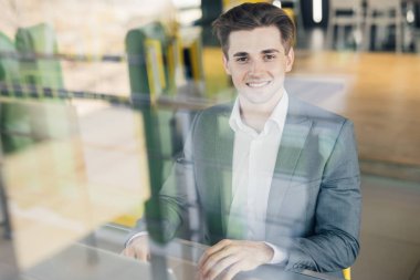 Başarılı girişimci, bilgisayarındaki bilgileri evde çalışırken kontrol ederken tatmin olmuş bir şekilde gülümsüyor.,