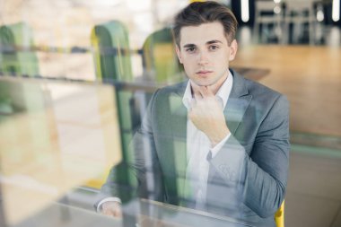 Konsantre genç işadamı çalışma dizüstü kentsel kafe sakallı. Ahşap masa kahve pencereden bakarak oturan adam. Coworking işlem iş başlangıç.