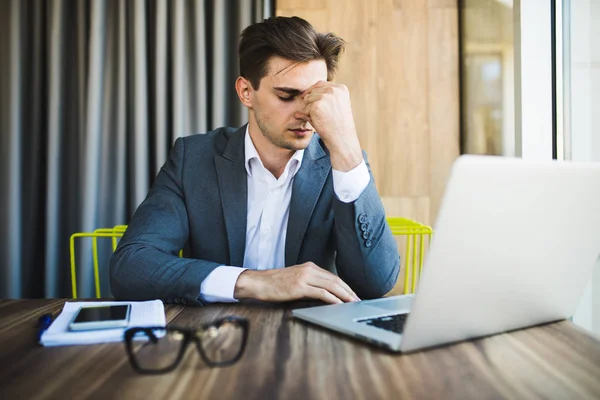 Jungunternehmer gestresste Jobs, Kopfschmerzen über den Job auf dem Tisch. — Stockfoto