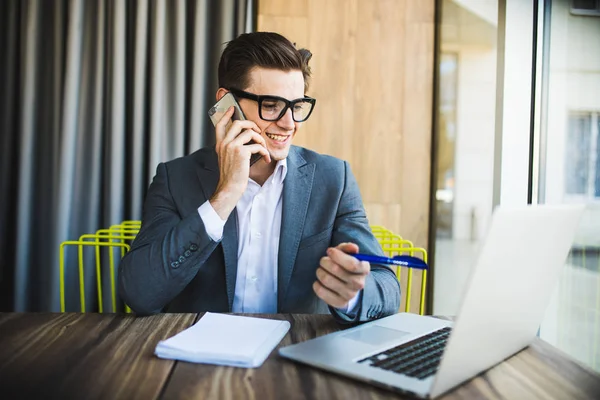 Sonriente hombre de negocios guapo tener hablar con sus clientes en la oficina — Foto de Stock