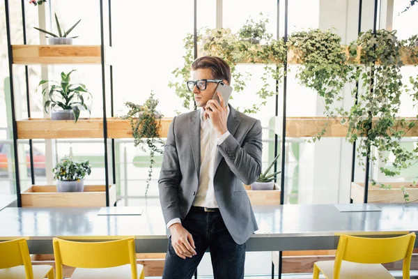 Stilig ung affärsman talar på telefon i moderna kontor — Stockfoto