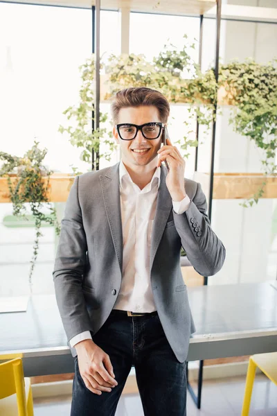 현대 사무실에서 전화에 잘생긴 젊은 프리랜서 비즈니스 남자 이야기 — 스톡 사진