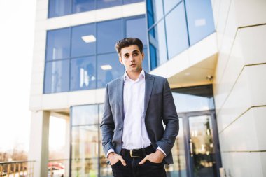 Ofis binası önünde yürürken cebinde zarif yakışıklı genç işadamı eller