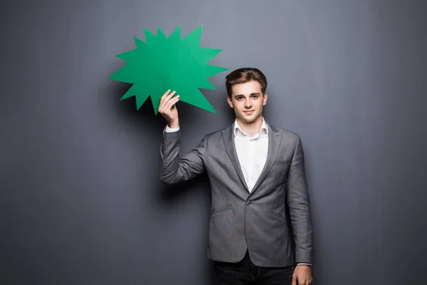 Homem segurando bolha de fala em branco verde com espaço para texto em fundo cinza — Fotografia de Stock