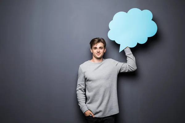 Hombre sosteniendo burbuja de voz en blanco azul con espacio para texto sobre fondo gris —  Fotos de Stock