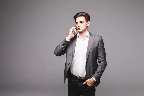 회색 배경에 고립 된 휴대 전화에 말하는 사업가의 초상화 — 스톡 사진
