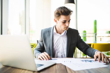 dizüstü bilgisayar ve çalışma office belgeleri ile işadamı