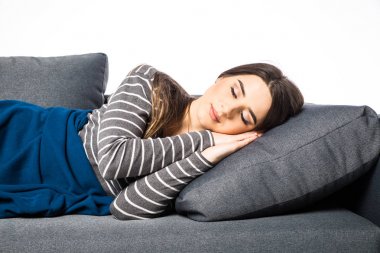 Beyaz arka plan üzerinde kanepede uyuyan güzel genç kadın