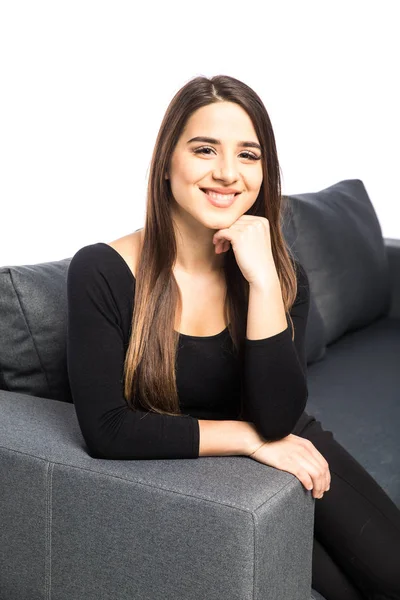 Portrait of happy young woman sitting on sofa on white background — Stock Photo, Image