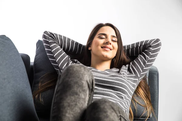 Femme relaxante assise sur un canapé avec les mains sur la tête sur fond blanc — Photo