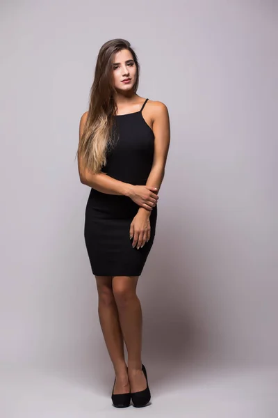 Retrato de longitud completa de una mujer sexy en pequeño vestido de moda negro en gris —  Fotos de Stock