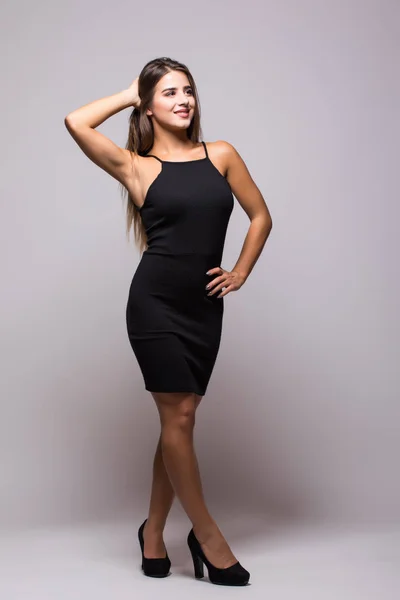 Retrato de longitud completa de una mujer sexy en pequeño vestido de moda negro en gris —  Fotos de Stock