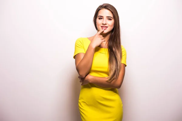Женщина-модель, стоящая в желтом платье на сером фоне — стоковое фото