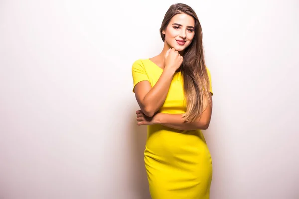 Nő divat modell állandó sárga ruhában, sötétszürke háttérrel — Stock Fotó