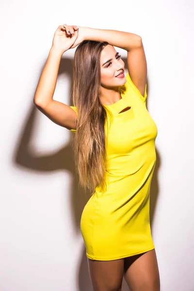 Γυναίκα μόδα μοντέλο στέκεται σε κίτρινο φόρεμα γκρι φόντο — Φωτογραφία Αρχείου