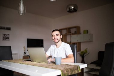 Mutfak sabahları laptop ve kahve Kupası ile yakışıklı adam