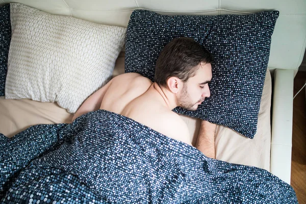 Jovem com rastreador de sono descansando na cama em casa — Fotografia de Stock