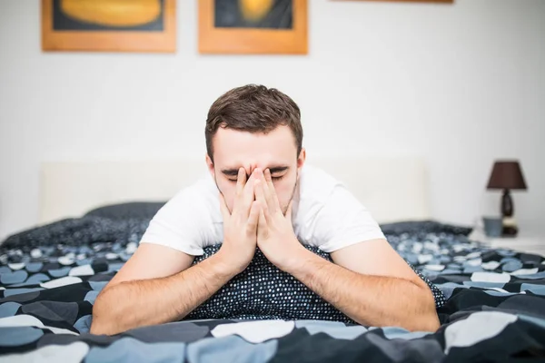 Homme se mouchant alors qu'il était couché malade dans son lit à la maison — Photo