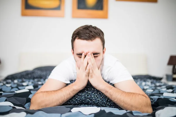 Homme se mouchant alors qu'il était couché malade dans son lit à la maison — Photo