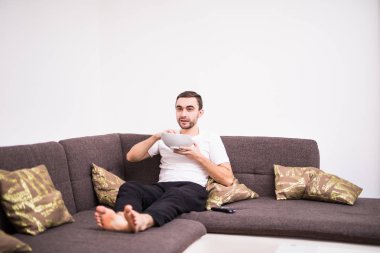 Yakışıklı delikanlı appartment bir kanepe evde TV izlerken
