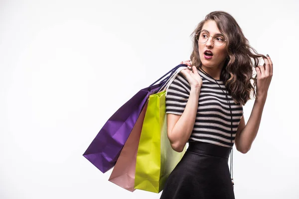 Jeune femme avec des sacs à provisions sur fond blanc criant et se demandant — Photo