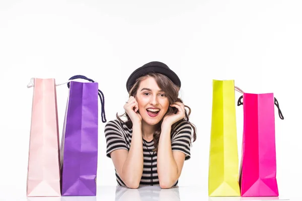 Young beautiful woman with shopping bags on table satisfied and have rest with happy smile on white background — Stock Photo, Image