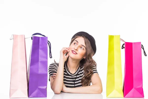 Young beautiful woman with shopping bags on table satisfied and have rest with happy smile on white background — Stock Photo, Image