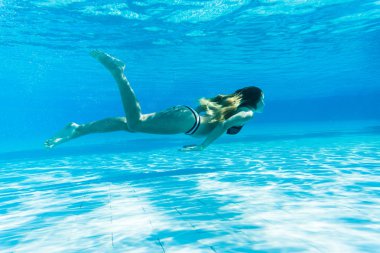Kız şnorkel yüzme havuzunda mavi su altında