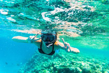 Snorkeling maske berrak Denizi suda ıslatın ve zafer işareti ile kadın