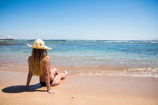 Женщина лежит на песке на берегу океана летний призвание — стоковое фото