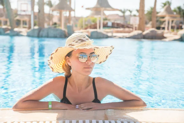 Linda chica en sombrero y gafas de sol en la piscina con espacio para copiar. Vocación de verano . —  Fotos de Stock