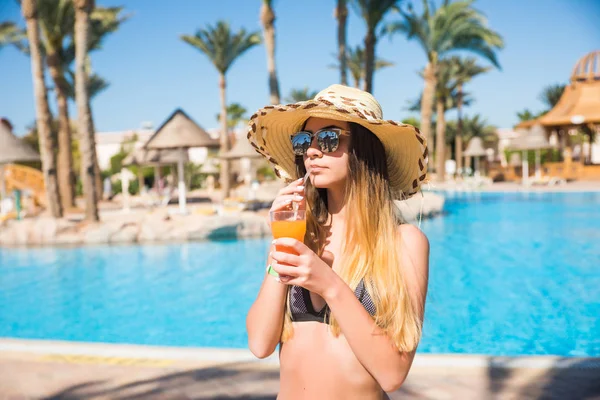 Kvinnor dricka cocktail nära poolen. Porträtt av vackra unga kvinnor dricka cocktail nära pool — Stockfoto