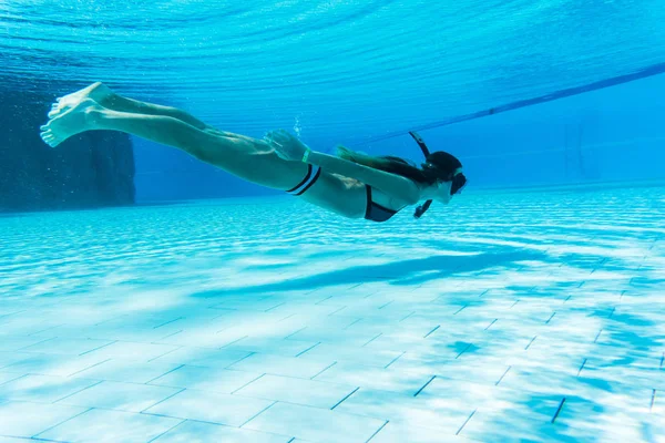 Vrouw met snorkelen masker onderwater zwemmen in zwembad — Stockfoto