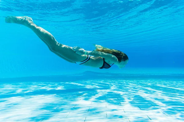 Lány merülés, búvárkodás a medencében, nyári vakációt kék víz alatt — Stock Fotó