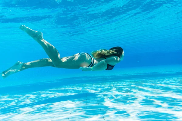 Meisje duik onder blauwe water snorkelen in een zwembad, zomer roeping — Stockfoto