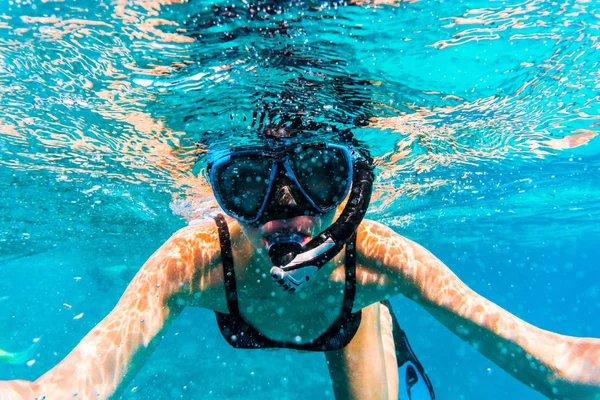 Vrouw met masker snorkelen in heldere zeewater — Stockfoto