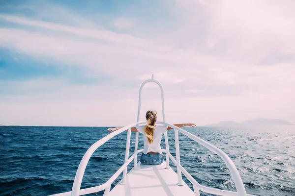 Fiatal nő előtt fehér jacht emelt kézzel orr élvezze a szél és a tenger. Nyári hivatása — Stock Fotó