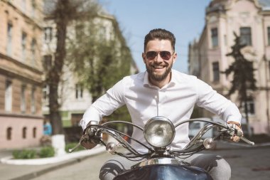 genç moda yaz sokakta vintage bir scooter sürme. tonda