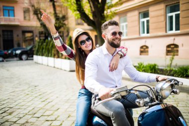 Bir cadde boyunca sürme ve gülümseyen güzel genç Çift