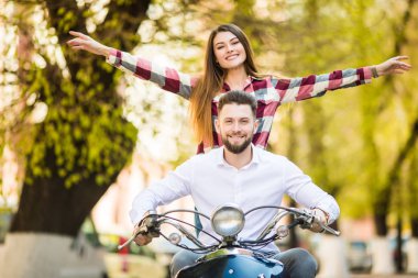 Güneşli güzel mutlu çift sürme scooter. Genç ve ücretsiz.