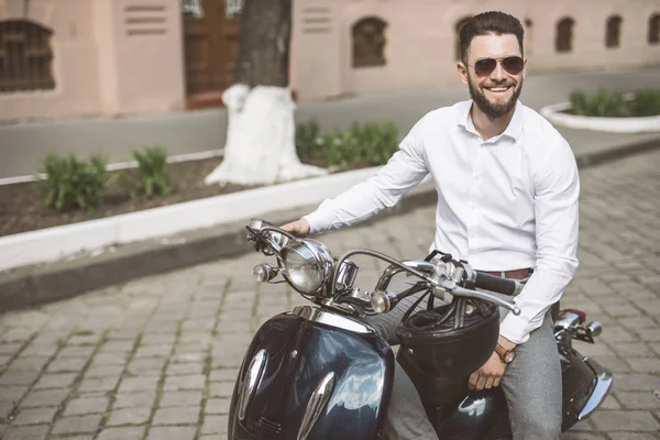 Веселый молодой человек едет на скутере в город. тонированные — стоковое фото