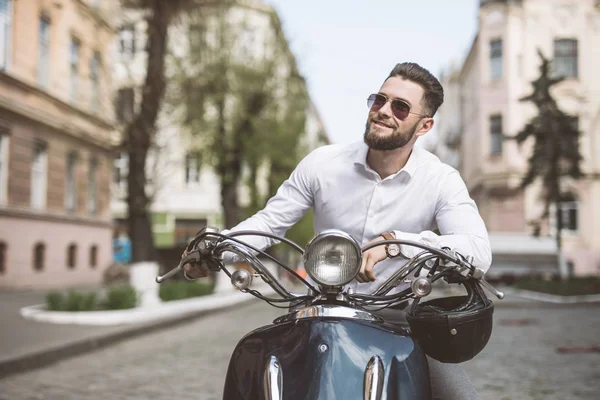 Bonito homem feliz montando uma moto na rua — Fotografia de Stock