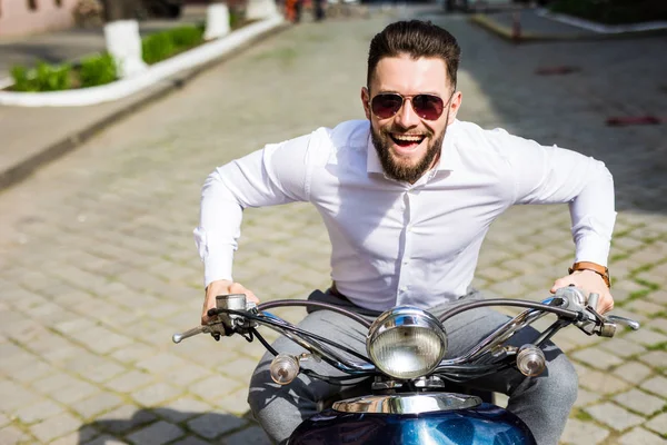 Jovem na moda montando uma scooter vintage na rua de verão — Fotografia de Stock