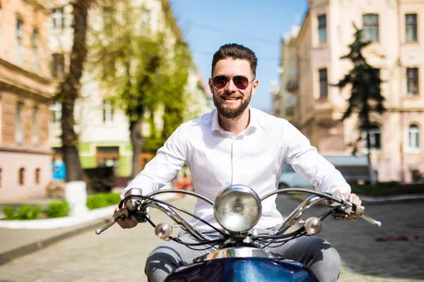 Modischer junger Mann auf einem Oldtimer-Roller in der Sommerstraße — Stockfoto