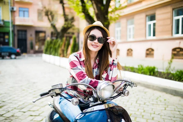 Feche a imagem de estilo de vida de mulher na moda jovem na roupa casual que se senta na scooter na rua. Mulher turística desfrutando de férias  . — Fotografia de Stock