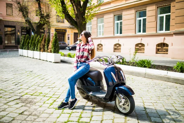 Mulher de beleza em scooter. Mulher jovem e bonita sentado scooter ao longo da rua — Fotografia de Stock