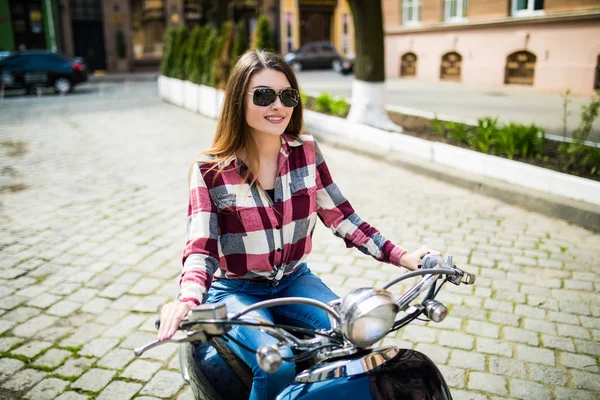 Mulher feliz atraente em uma scooter na rua da cidade — Fotografia de Stock