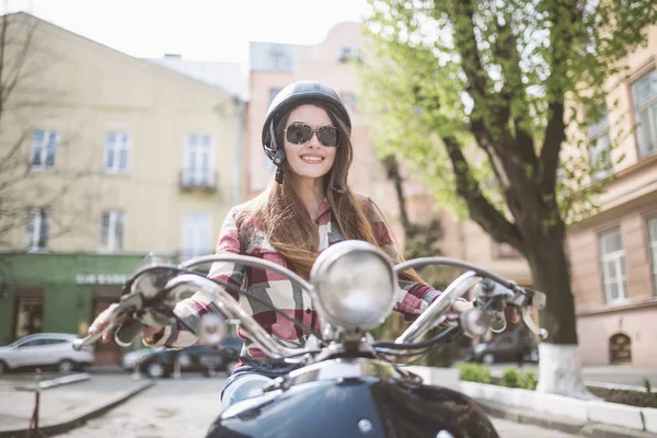 Podekscytowany, młoda i piękna kobieta jazdy skuter wzdłuż ulicy i uśmiech. stonowanych — Zdjęcie stockowe