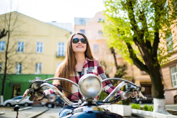 Mulher feliz atraente em uma scooter na rua da cidade — Fotografia de Stock